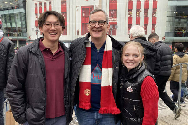 Two students and a professor outside Emirates Stadium.